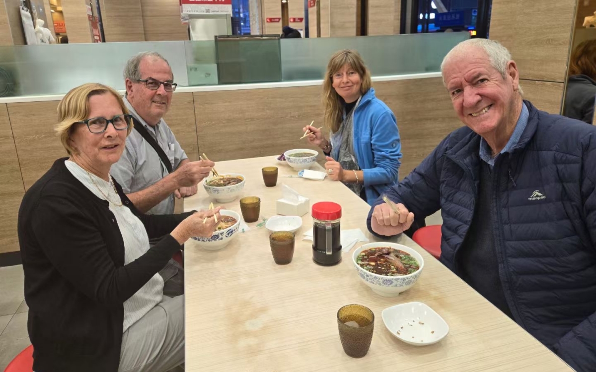 Travelers having noodles at a restaurant