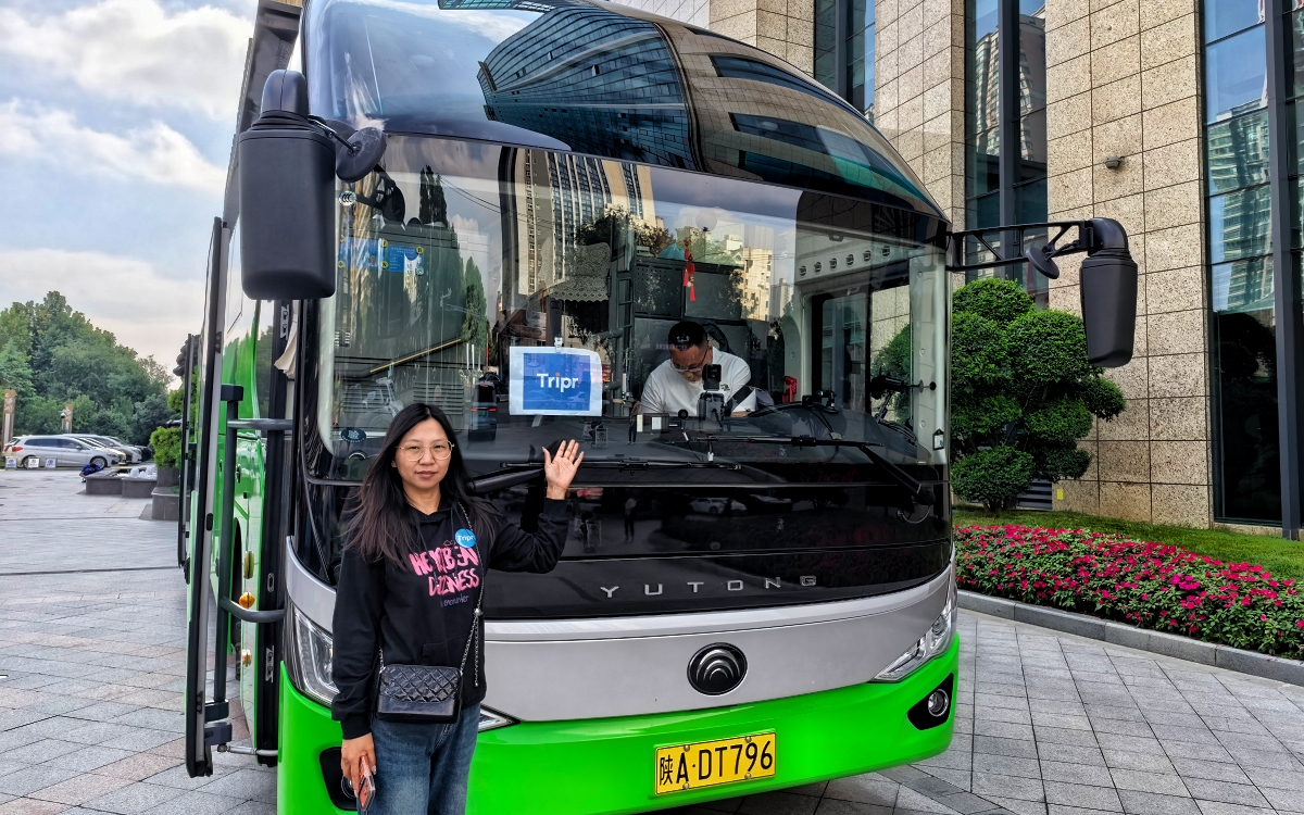 Local representative beside a tour coach with the travel partner’s sign displayed in the windscreen